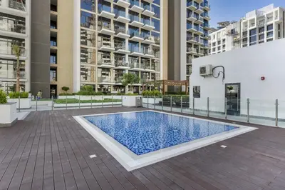 a swimming pool in front of some buildings at Studio in Azizi with Pool and Gym Access in Dubai