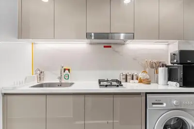 a kitchen with a sink and a washing machine at Studio in Azizi with Pool and Gym Access in Dubai