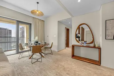 a living room with a table and a mirror at Guest Favorite - Elegant & Stylish 2BR Stay at Vida Creek Harbour in Dubai