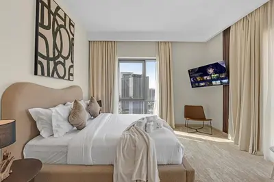 a hotel room with a bed and a tv at Guest Favorite - Elegant & Stylish 2BR Stay at Vida Creek Harbour in Dubai
