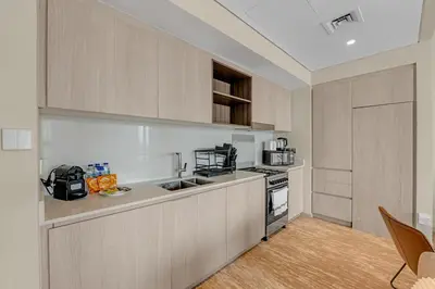 a kitchen with a stove and a counter top at Guest Favorite - Elegant & Stylish 2BR Stay at Vida Creek Harbour in Dubai