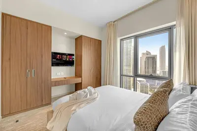 a bedroom with a white bed and a large window at Guest Favorite - Elegant & Stylish 2BR Stay at Vida Creek Harbour in Dubai