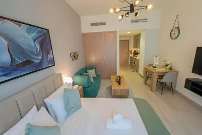 a living room with a bed and a living room with a couch at Chic Urban Studio in Dubai in Dubai