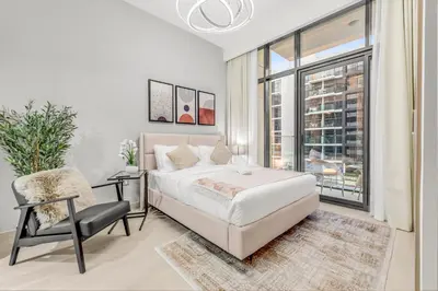 a bedroom with a bed and a chair and a window at Fully Furnished Studio with Scenic Views in Dubai