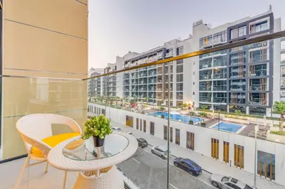 a balcony with a table and chairs and a view of a city at Fully Furnished Studio with Scenic Views in Dubai