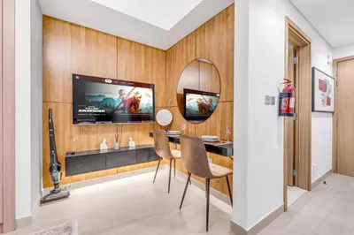 a living room with a tv and a table and chairs at Fully Furnished Studio with Scenic Views in Dubai