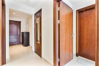 a hallway with wooden doors and a hallway with white walls at Chic 1BR with City Views Near Marina & Metro in Dubai