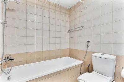 a bathroom with a toilet and a bath tub at Chic 1BR with City Views Near Marina & Metro in Dubai