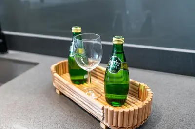 two bottles and a wine glass in a basket at Amazing 2BR Peaceful Views in Midtown Near Sports City in Dubai