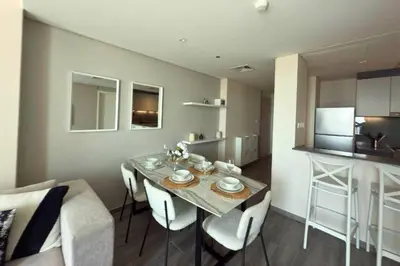 a dining room and kitchen with a table and chairs at Amazing 2BR Peaceful Views in Midtown Near Sports City in Dubai