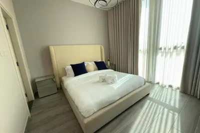 a bedroom with a large bed with blue pillows at Amazing 2BR Peaceful Views in Midtown Near Sports City in Dubai