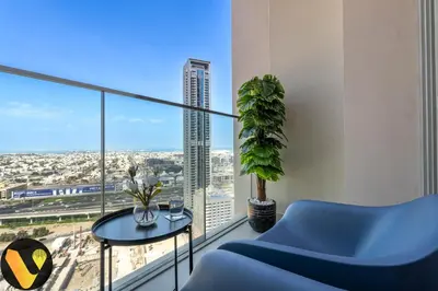 a living room with a blue couch and a table and window at Vogue Downtown Forte near Dubai Mall and Burj Khalifa, Two-Bedroom Apartment with Balcony and City View, full access to all amenities in Dubai