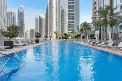 a large swimming pool in a city with tall buildings at Vogue Downtown Forte near Dubai Mall and Burj Khalifa, Two-Bedroom Apartment with Balcony and City View, full access to all amenities in Dubai