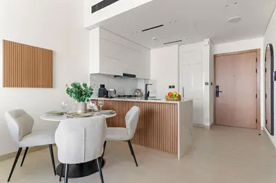 a kitchen and dining room with a table and chairs at VayK - Brand New and Bright 1BR in JVC in Dubai