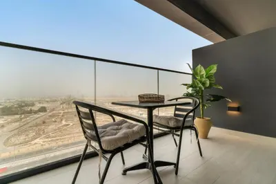 a table and chairs in a room with a large window at VayK - Brand New and Bright 1BR in JVC in Dubai