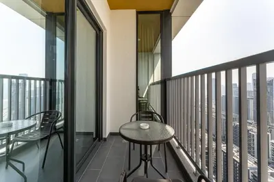 a balcony with a table and chairs on a building at HAVN - 2 Bedroom at The Crest, Dubai Skyline Views in Dubai