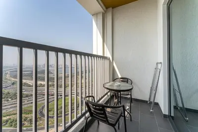 a balcony with a table and chairs on a building at HAVN - 2 Bedroom at The Crest, Dubai Skyline Views in Dubai