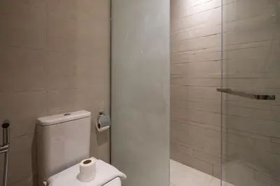 a bathroom with a toilet and a glass shower at Stylish Studio Apartment in Azizi Riviera One in Dubai