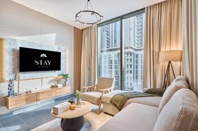 a living room with a couch and a tv at STAY BY LATINEM Luxury 2BR Holiday Home CC 1014 Near Burj Khalifa in Dubai