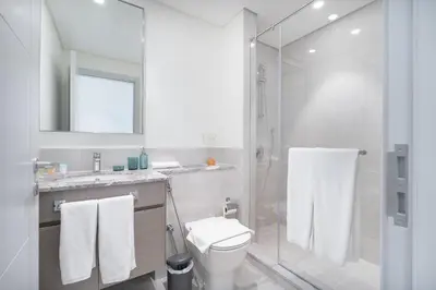 a bathroom with a toilet and a glass shower at Vogue Downtown Forte near Dubai Mall and Burj Khalifa, Two-Bedroom Apartment with Balcony and City View, full access to all amenities in Dubai
