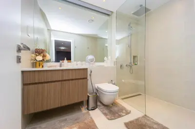 a bathroom with a toilet and a glass shower at NEU Sea and Burj View Port de La Mer in Dubai