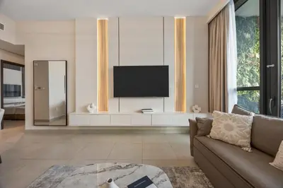 a living room with a couch and a television at 2BR Apt Direct Dubai Mall Access Burj View in Dubai