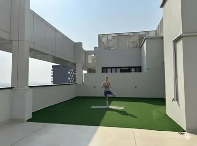 a woman standing on the floor of a building at Gym Spa Padel & E-scooter Designer Brand New 2BR in Dubai