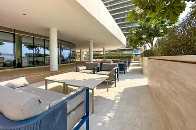 a patio with couches and tables in front of a building at Chic 2 bedroom w Sunset and Palm Jumeirah Views in Dubai