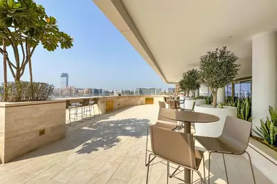 a patio with tables and chairs on a building at Chic 2 bedroom w Sunset and Palm Jumeirah Views in Dubai