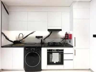 a kitchen with a stove and a washing machine at Modern Studio with Private Jacuzzi in Dubai