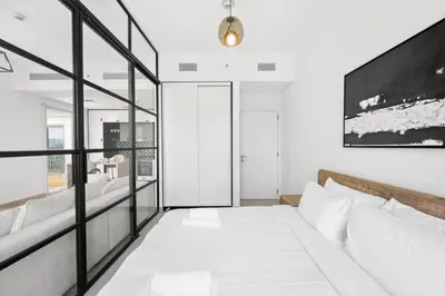 a living room with a bed and a large window at Dubai Hills 2BR Collective Tower in Dubai