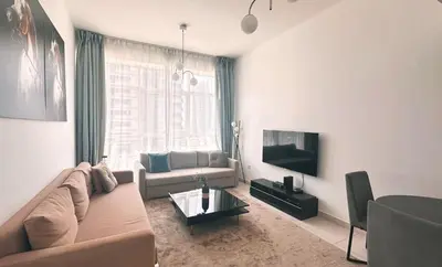a living room with a couch and a tv at Marine View Tower aparthotel in Dubai
