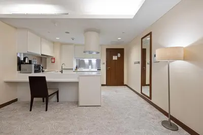 a kitchen with a table and a chair in a room at Abi Holiday Homes - Studio & 1BR Dubai Mall Fashion Avenue Residences in Dubai