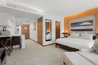a bedroom with a large bed and a kitchen at Abi Holiday Homes - Studio & 1BR Dubai Mall Fashion Avenue Residences in Dubai