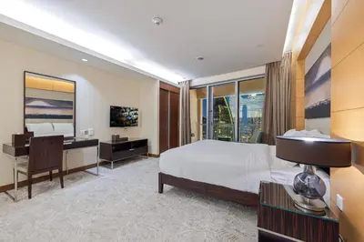 a hotel room with a bed and a desk and a television at Abi Holiday Homes - Studio & 1BR Dubai Mall Fashion Avenue Residences in Dubai