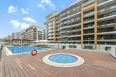 a swimming pool in front of a large building at Modern Studio, Swimming Pool, Balcony, and Close to Burj Khalifa in Dubai