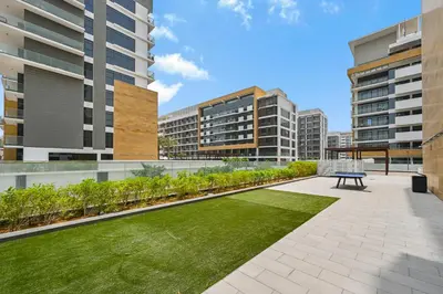a courtyard with a bench and grass in a building at Modern Studio, Swimming Pool, Balcony, and Close to Burj Khalifa in Dubai