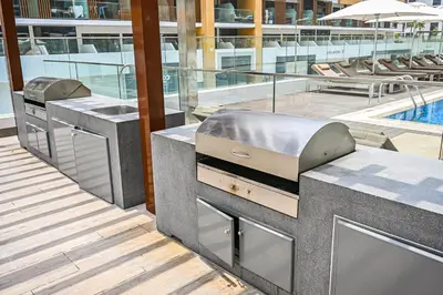 a kitchen with a grill and a swimming pool at Modern Studio, Swimming Pool, Balcony, and Close to Burj Khalifa in Dubai