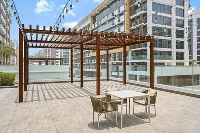 a pergola with a table and chairs on a patio at Modern Studio, Swimming Pool, Balcony, and Close to Burj Khalifa in Dubai