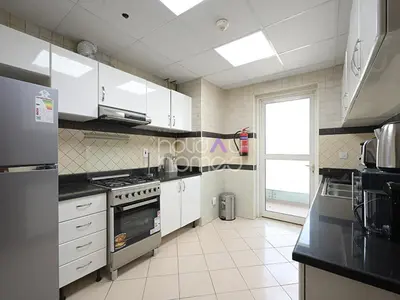 a kitchen with white appliances and a large window at Spacious 3BR in Zen Tower Dubai Marina in Dubai