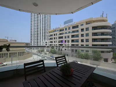 a balcony with a table and chairs and a building at Spacious 3BR in Zen Tower Dubai Marina in Dubai