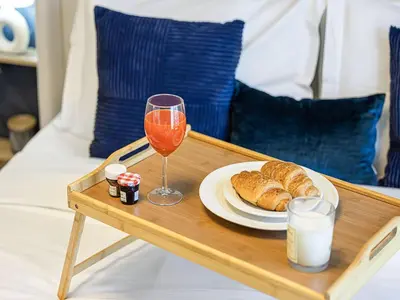 a table with a plate of bread and a glass of wine at Livin' Holidays - Studio - Azizi Near Downtown in Dubai