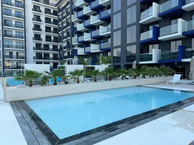 an empty swimming pool in front of a building at Stylish One Bedroom Apartment at Binghatti Crest, JVC Dubai By al sarya Holiday Homes in Dubai