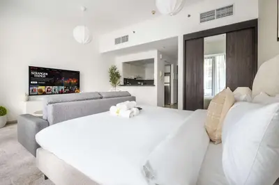 a bedroom with a large white bed and a couch at StayShort - Dubai Marina sleeps 4 with Water Views! in Dubai