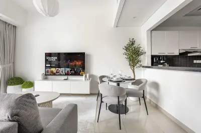 a living room with a table and a kitchen at StayShort - Dubai Marina sleeps 4 with Water Views! in Dubai