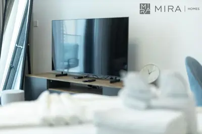 a living room with a large television on a table at Mira Holiday Homes - Paragon by IGO Studio Where Style Meets Comfort in Dubai