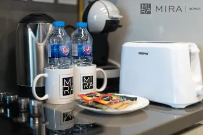 a counter with two bottles of water and a plate of food at Mira Holiday Homes - Paragon by IGO Studio Where Style Meets Comfort in Dubai