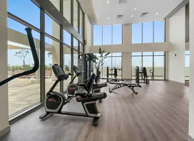 a gym with treadmills and ellipticals in a room with windows at Elegant Apartment with Burj Khalifa View in Dubai