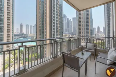 a balcony with a table and chairs and a view of the city at Vogue Downtown Boulevard Central near Burj Khalifa and Dubai Mall, Two Bedroom Apartment with Balcony and Burj Khalifa View, Access to all Amenities in Dubai