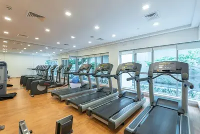 a gym with a row of treadmills and ellipticals at Vogue Downtown Boulevard Central near Burj Khalifa and Dubai Mall, Two Bedroom Apartment with Balcony and Burj Khalifa View, Access to all Amenities in Dubai